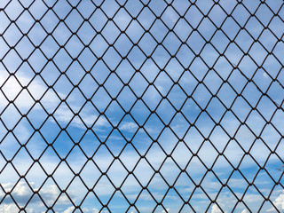 Iron wire mesh fence,chain link fence with blue sky and clouds