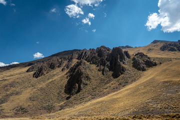 Harsh rock protrusions force their way out through the mountain side lining the Sacred Valley