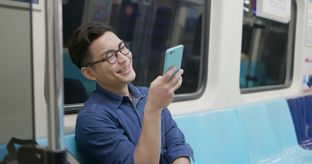 man use phone in MRT