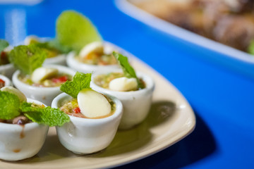 Fresh blood cockle or blood clam in spicy seafood sauce served in mini cup.