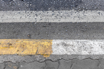 Yellow and white lines on footpath
