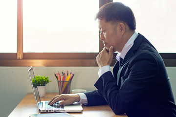 Business woman working in office with checking business report in a tablet. using a tablet computer for money analyzing graphs