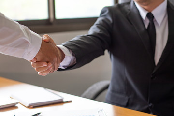 Obraz premium Close up view of business partnership handshake concept.Photo of two businessman handshaking process.businessman shaking hands in office. Collaborative teamwork