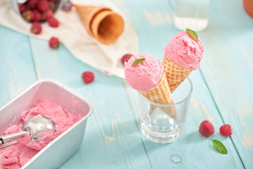 Homemade raspberry ice cream in waffle cones.