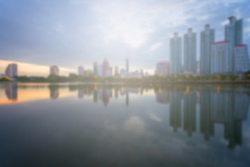 Fototapeta na wymiar Blur City building with water reflection before sunset