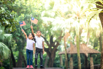 Boy and Girl with Malaysia Flag. Independence Day concept. Outdoor Setting