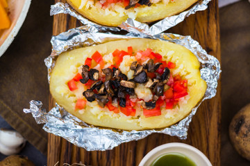 Baked stuffed potatoes with vegetables in foil. Homemade vegan food. 