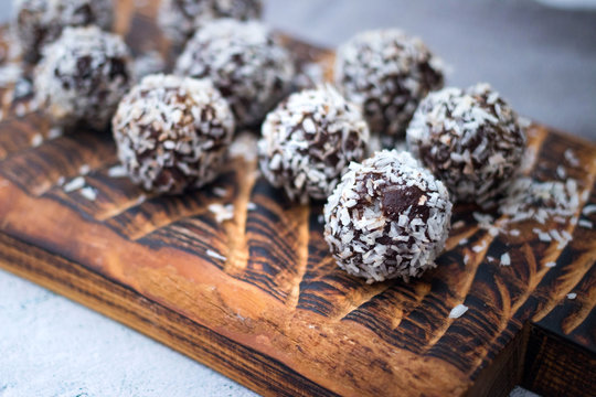 Coconut Sweet Balls. Energy Protein Dessert With Dates, Cocoa, Peanut Butter On Wooden Board