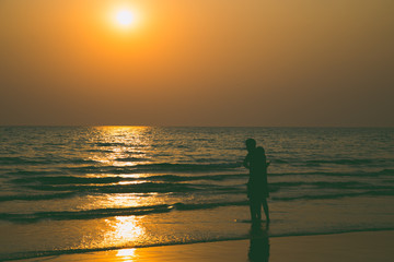 Fototapeta premium Siluate lovers and beach before sunset
