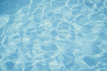 Blue pool water with sun reflections