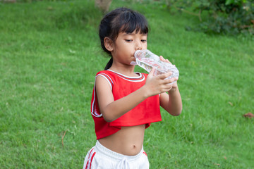 Girls drink water from plastic bottles. To quench thirst after exercise.