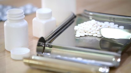 Medicine tablets on counting tray with counting spatula at pharmacy