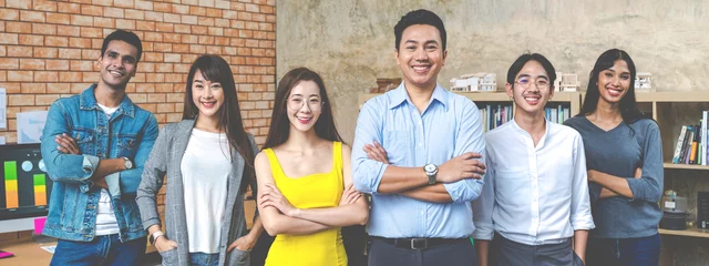 Foto op Canvas Banner of Group asian employee are standing and looking at camera with feeling confident at workplace company. Portait of Asian creative team posing in workspace. © ChayTee