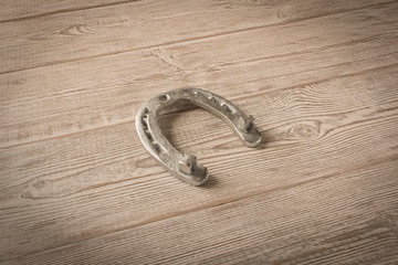 Silver horseshoe on a wooden table. An old horseshoe.