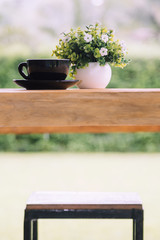 Coffee cup on old wooden table with nature background