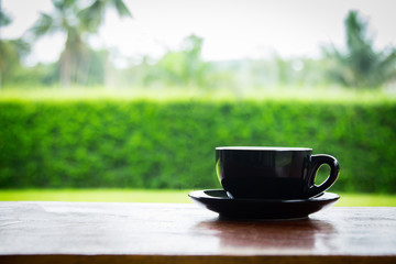 Coffee cup on old wooden table with nature background