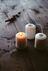 Fototapeta na wymiar White Candles Burning On Wooden Tabletop