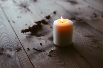 Obraz na płótnie Canvas White Candle Burning On Wooden Tabletop
