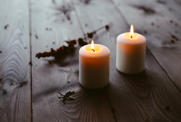 Fototapeta na wymiar White Candles Burning On Wooden Tabletop