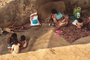 A poor family of six people living on the floor at the roadside with bare essentials.