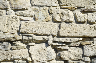 the texture of the historic stone wall of light yellow color close-up