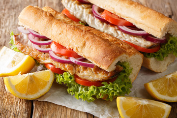 Hearty delicious turkish sandwich balik emek with grilled mackerel served with lemon closeup on the table. horizontal