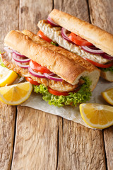 Traditional turkish fast food sandwich balik Ekmek with grilled mackerel and vegetables close-up. vertical
