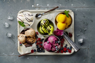 Assorted flavors and colors of gourmet Italian ice cream served on steel table. Mango, chocolate,...