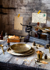 table setting with round vintage plates with crumbs of cake and gold spoons on grey wooden table