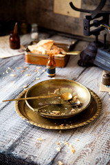 table setting with round vintage plates with crumbs of cake and gold spoons on grey wooden table