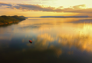 Aerial view, Beautiful Orange and red dramatic colors of sunset and cirrus clouds above the sea. Sky blue and orange natural dawn composition over the sea, Warm colors with pontoon and mountain.