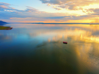 Aerial view, Beautiful Orange and red dramatic colors of sunset and cirrus clouds above the sea. Sky blue and orange natural dawn composition over the sea, Warm colors with pontoon on the sea.