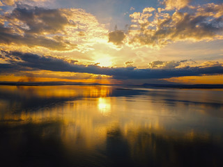 Aerial view, Beautiful Orange and red dramatic colors of sunset and cirrus clouds above the sea. Sky blue and orange natural dawn composition over the sea, Warm colors reflect the water surface.