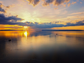 Aerial view, Beautiful Orange and red dramatic colors of sunset and cirrus clouds above the sea. Sky blue and orange natural dawn composition over the sea, Warm colors reflect the water surface.