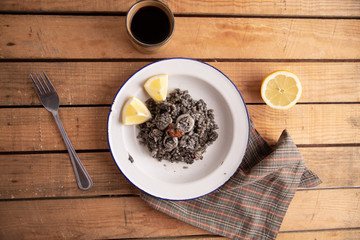 Plate of black rice with squid and prawns or Valencian black paella