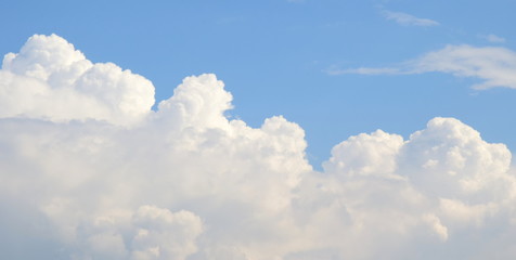 Naklejka na ściany i meble Weiße Haufenwolken vor blauen Himmel - Regenwolken