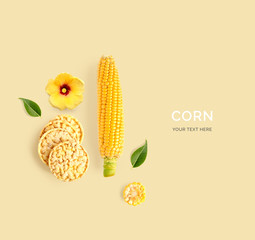 Creative layout made of corn, corn cake, green leaves, flower and corn pasta on yellow background. Flat lay. Food concept. Macro  concept.