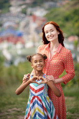 Obraz premium Woman smiling while standing with her adopted daughter