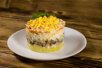 Traditional russian salad Mimosa on wooden table