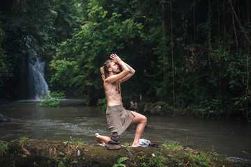 Yoga practice and meditation in nature. Man practicing near river