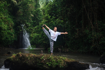 Yoga practice and meditation in nature. Man practicing near river