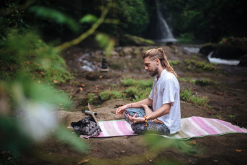 Yoga practice and meditation in nature. Man practicing near river
