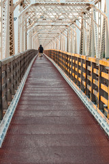 朝の淀川に架かる鉄橋を渡る人