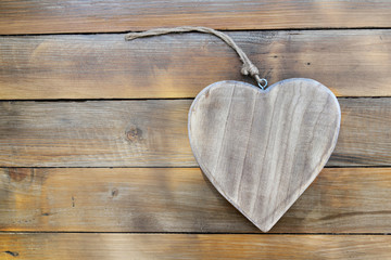 big wooden heart shaped on rustic plank background