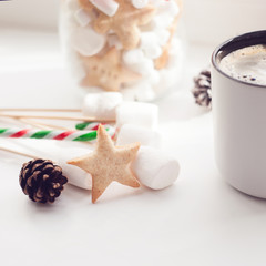 Cup of hot Chocolate drink with marshmallows, cinnamon sticks, anise star, gift and cones on white background. Winter christmas holiday background.