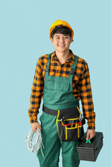 Male electrician on color background