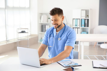 Fototapeta na wymiar Male nurse working on laptop in clinic