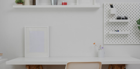 Minimal white workplace with mock up frame  and office supplies on white table