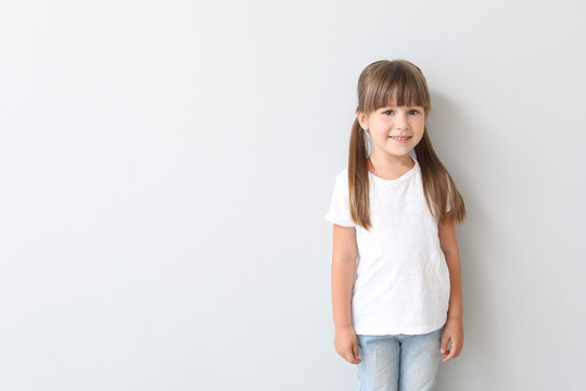 Little girl in stylish t-shirt on light background