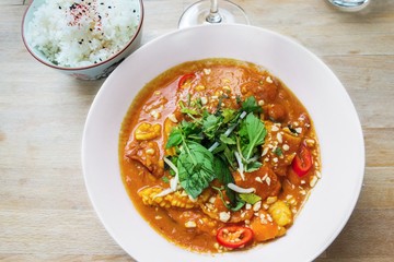 Red asian curry with seafood, bowl with rice.